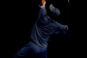 Andy Roddick reaching out into sunlight at Pat Rafter Arena