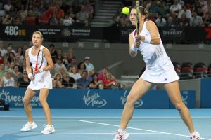 Klaudia Jans hits a backhand while Alicja Rosolska watches. SMP IMAGES