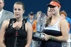 Anastasia Pavlyuchenkova (left) thanks the Pat Rafter Arena crowd while Alisa Kleybanova holds the winners' trophy. SMP IMAGES