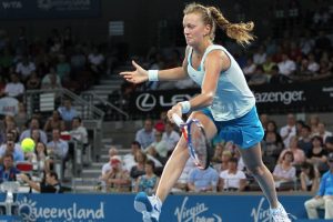 Kvitova jumps high for the ball.