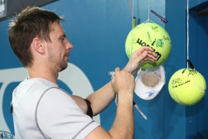 Robin Soderling signs giant tennis balls for fans.