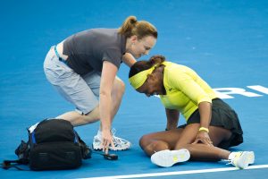 A trainer rushes to Serena Williams's aid after she falls during her second-round match against Bojana Jovanovski. SMP IMAGES